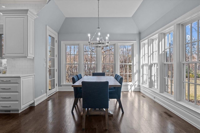 dining space featuring dark wood-style floors, visible vents, vaulted ceiling, and an inviting chandelier