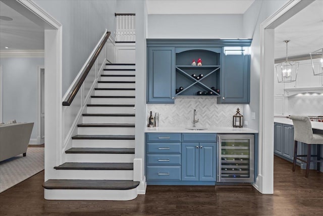 bar featuring stairs, dark wood-type flooring, a sink, beverage cooler, and indoor wet bar