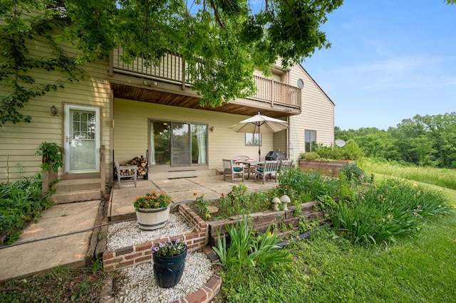 back of house featuring a balcony and a patio area