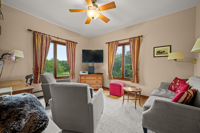 living room featuring baseboard heating, baseboards, ceiling fan, and wood finished floors