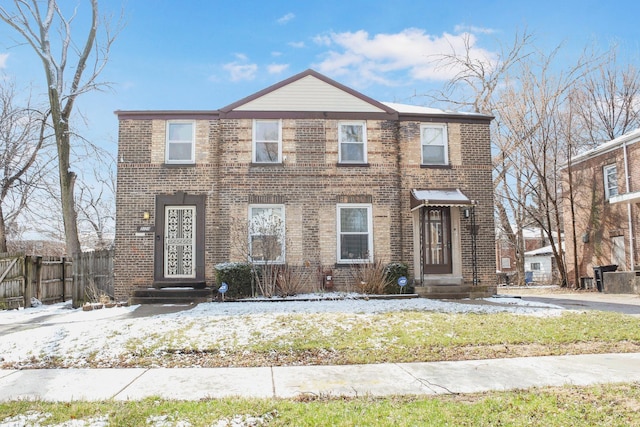 view of front of house featuring brick siding and fence
