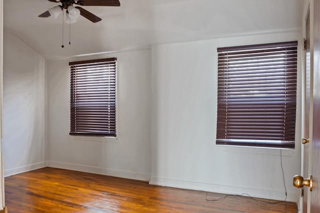 empty room with baseboards, wood finished floors, ceiling fan, and a wealth of natural light