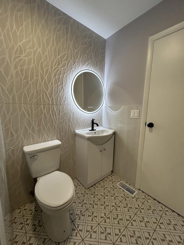 bathroom featuring vanity, visible vents, and toilet