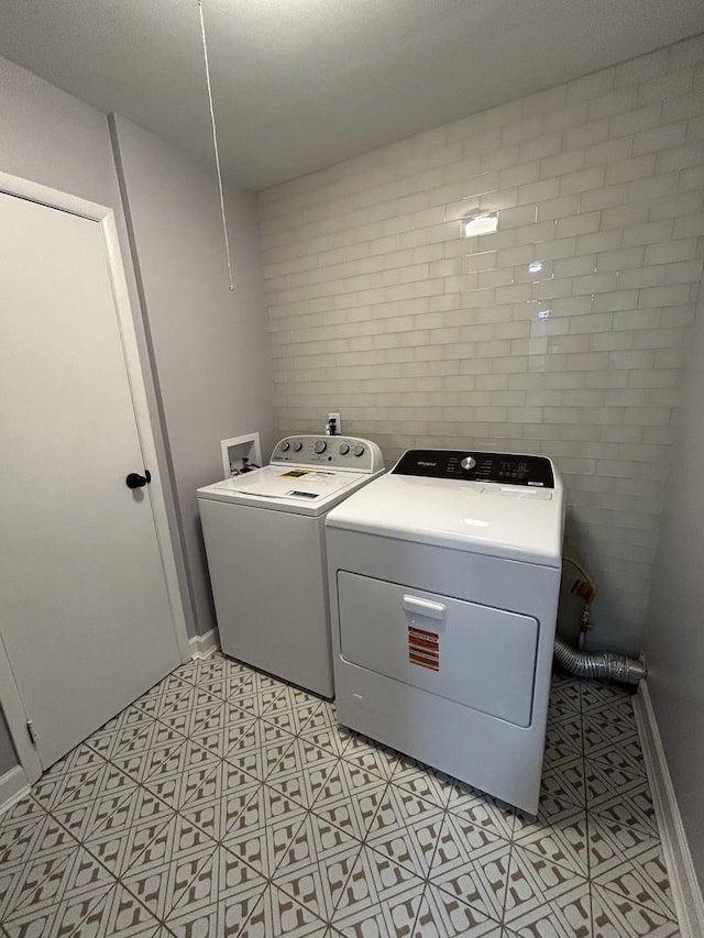 laundry area with baseboards, washing machine and dryer, and laundry area