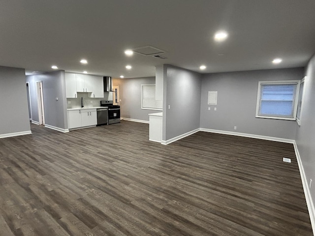 unfurnished living room with dark wood-style flooring, baseboards, visible vents, and recessed lighting