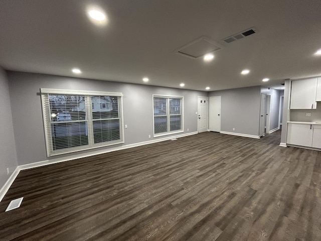 interior space with recessed lighting, dark wood-type flooring, visible vents, and baseboards