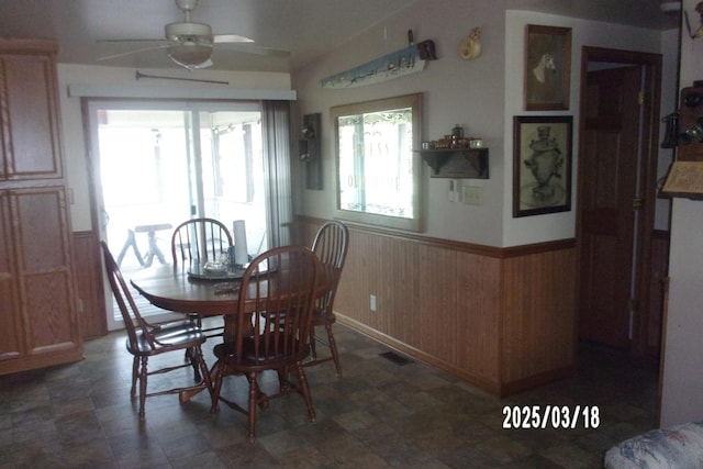 507 N Fifth St, Ashkum, IL 60911 - dining space featuring a wainscoted wall, ceiling fan, and wooden walls