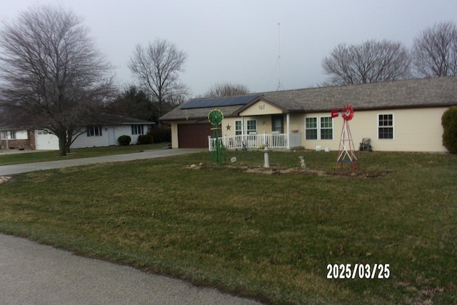 507 N Fifth St, Ashkum, IL 60911 - single story home with concrete driveway, an attached garage, a front yard, covered porch, and roof mounted solar panels