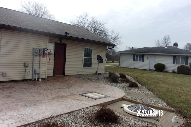 507 N Fifth St, Ashkum, IL 60911 - back of property featuring a lawn, a shingled roof, and a patio area