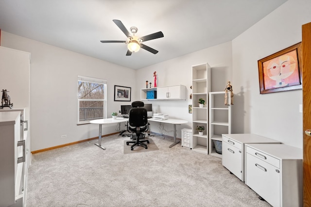 office featuring ceiling fan, light carpet, and baseboards