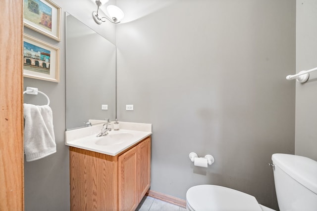 half bathroom with toilet, vanity, and tile patterned flooring