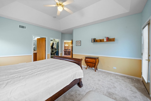 bedroom featuring a raised ceiling, a closet, a spacious closet, and visible vents
