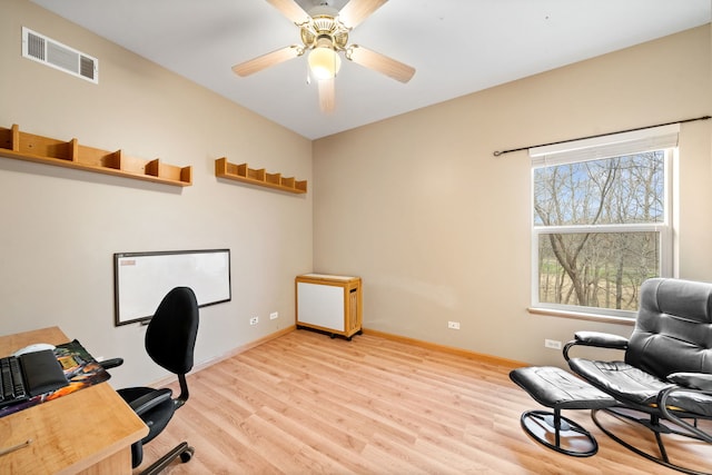 office space with visible vents, baseboards, a ceiling fan, and light wood-style flooring