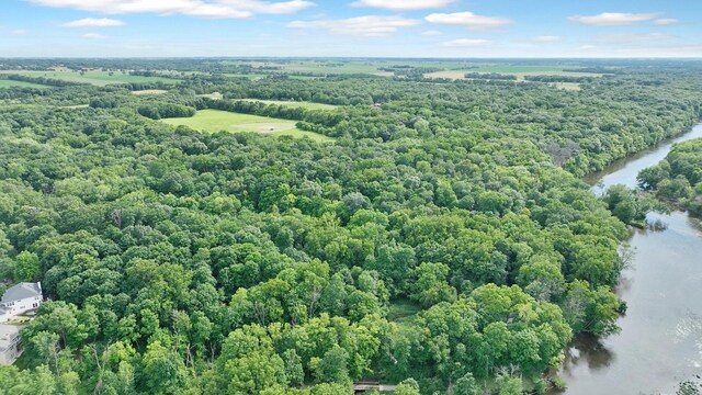 birds eye view of property with a view of trees and a water view