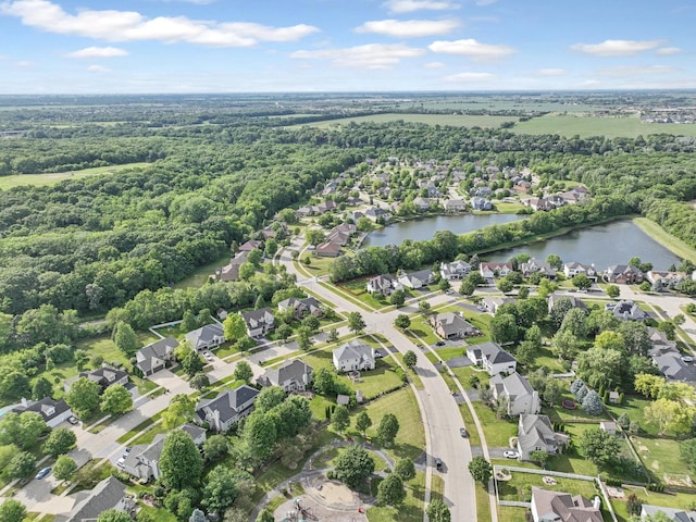 aerial view featuring a water view, a view of trees, and a residential view