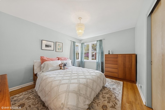 807 Webster Ave, Wheaton, IL 60187 - bedroom with light wood-type flooring, baseboards, a notable chandelier, and a closet