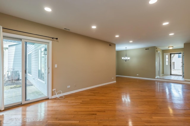 empty room with recessed lighting, visible vents, light wood-style floors, and a notable chandelier