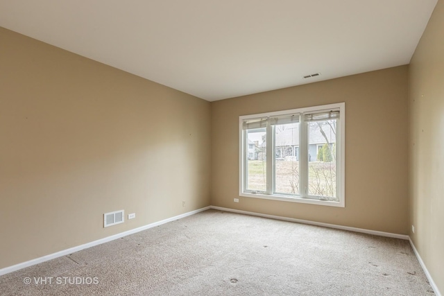 spare room with baseboards, carpet floors, and visible vents