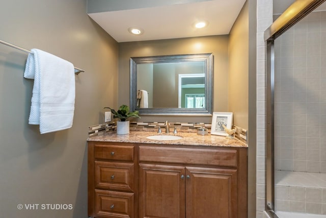 full bathroom featuring recessed lighting, tiled shower, and vanity