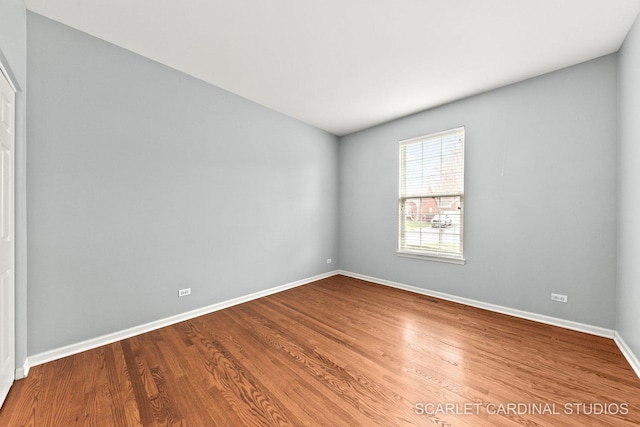unfurnished room featuring baseboards and wood finished floors