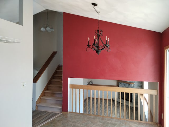 staircase featuring vaulted ceiling and a chandelier