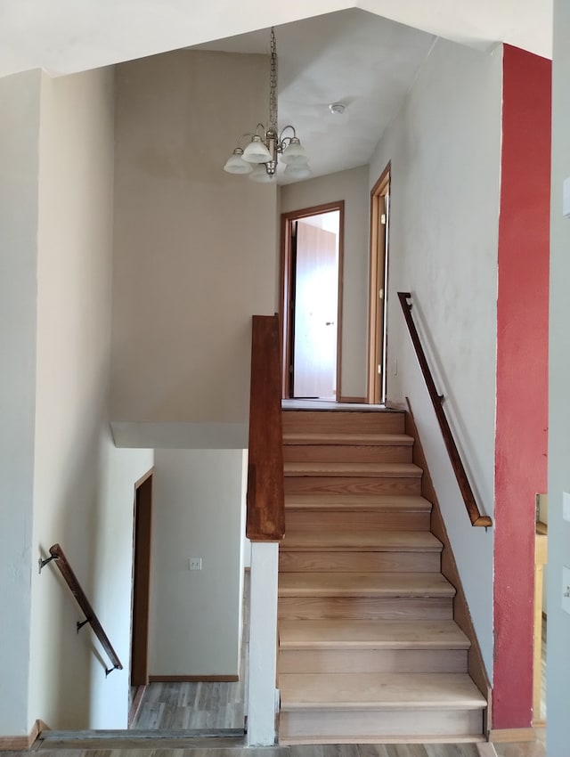 stairway featuring an inviting chandelier