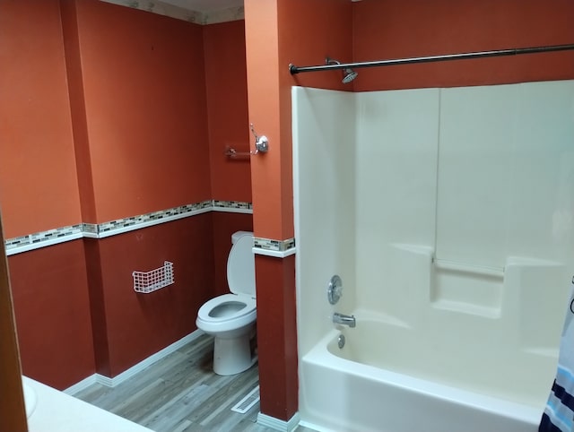 full bathroom with  shower combination, visible vents, wood finished floors, and toilet