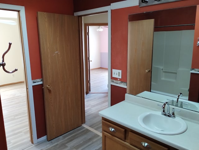bathroom with vanity, baseboards, and wood finished floors