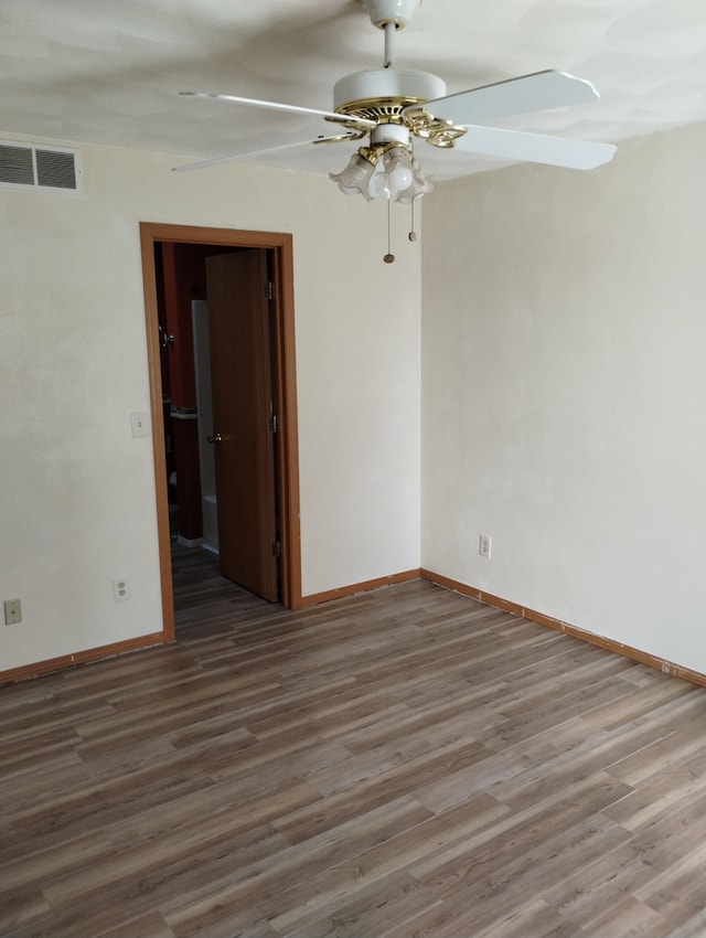 unfurnished room with baseboards, ceiling fan, visible vents, and wood finished floors