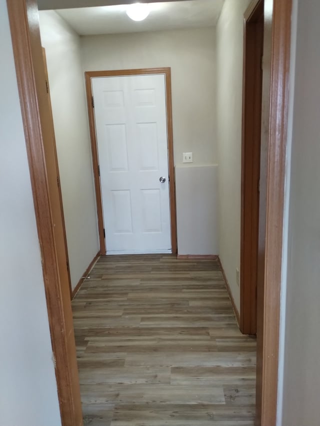 hall with baseboards and light wood-type flooring