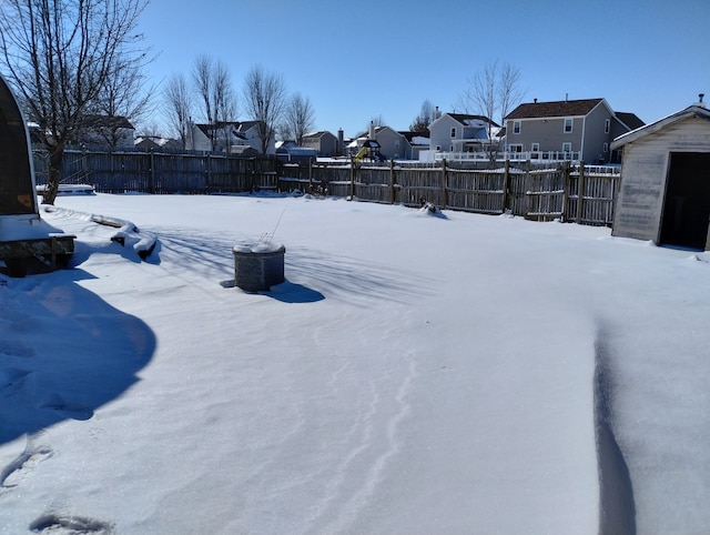yard covered in snow featuring a fenced backyard and a residential view