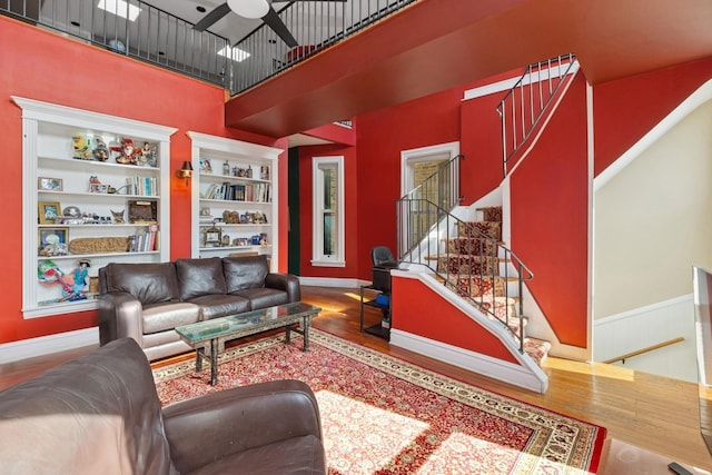 1957 W Schiller St, Chicago, IL 60622 - living area with wood finished floors, a ceiling fan, a high ceiling, stairway, and a wainscoted wall