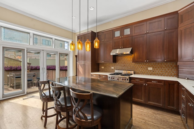 1957 W Schiller St, Chicago, IL 60622 - kitchen with under cabinet range hood, stove, light wood finished floors, ornamental molding, and backsplash