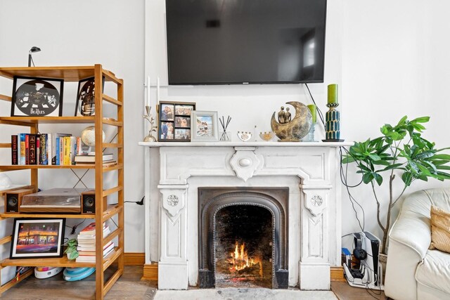 living room with a fireplace with flush hearth and wood finished floors