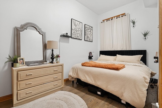 bedroom featuring baseboards and wood finished floors