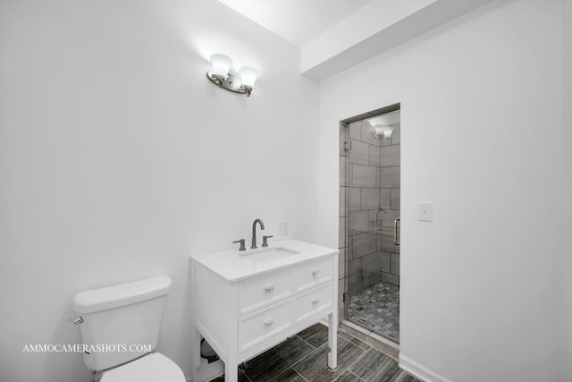 bathroom featuring toilet, a stall shower, and vanity