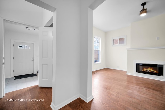 corridor featuring baseboards and wood finished floors
