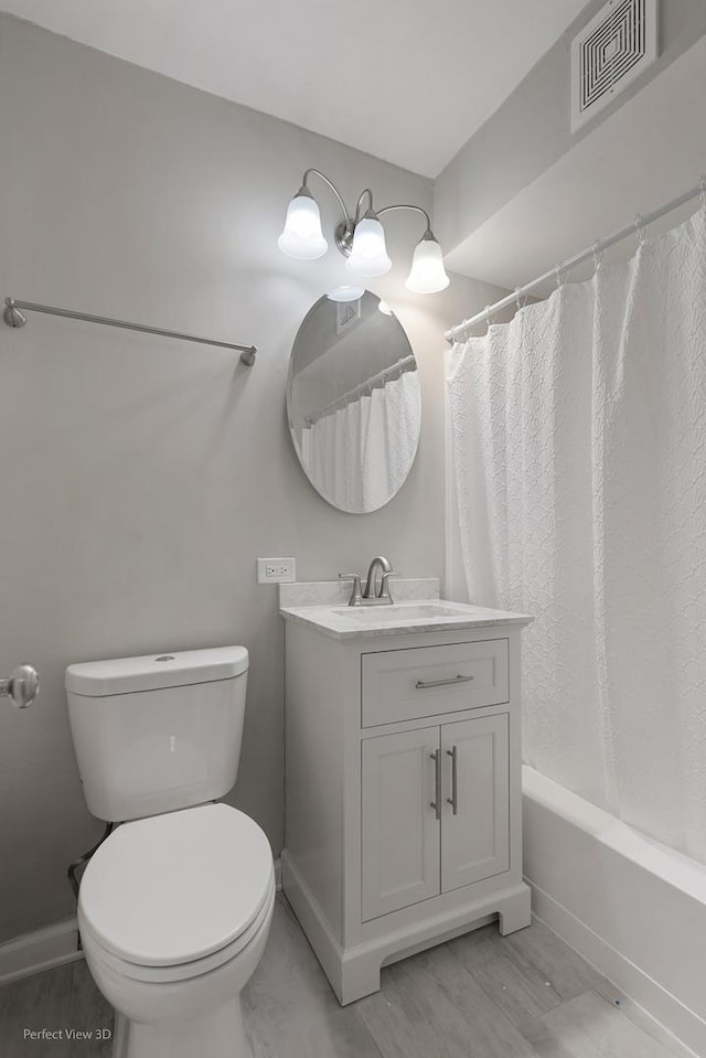 bathroom featuring visible vents, baseboards, shower / bath combo with shower curtain, toilet, and vanity
