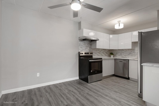kitchen featuring a ceiling fan, white cabinetry, appliances with stainless steel finishes, light countertops, and decorative backsplash
