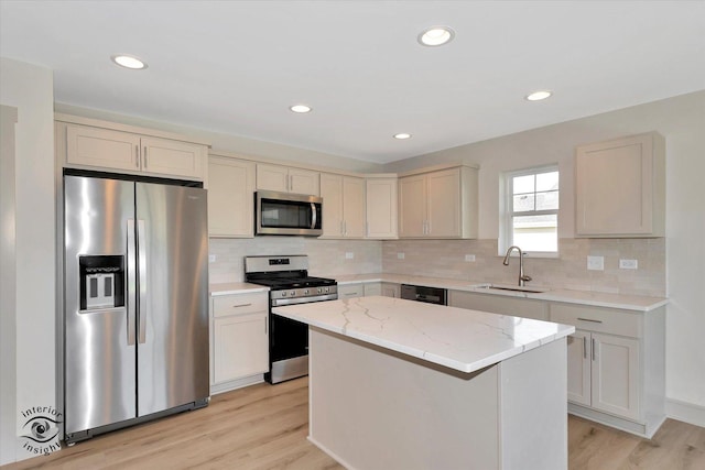 5656 Lantern Ln, Bourbonnais, IL 60914 - kitchen featuring light stone countertops, a kitchen island, a sink, stainless steel appliances, and light wood-style floors