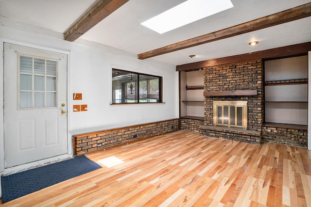 2201 W Acres Rd, Joliet, IL 60435 - unfurnished living room with beam ceiling, wood finished floors, and a brick fireplace