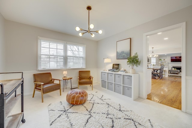 living area featuring a chandelier and carpet