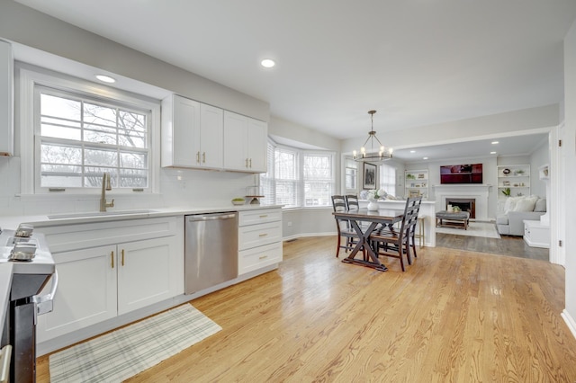 kitchen with dishwasher, white cabinetry, light wood-style flooring, and a sink