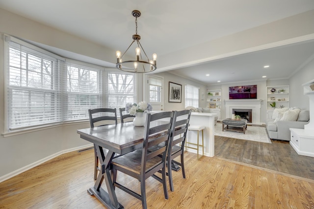 dining space featuring visible vents, baseboards, an inviting chandelier, wood finished floors, and a fireplace