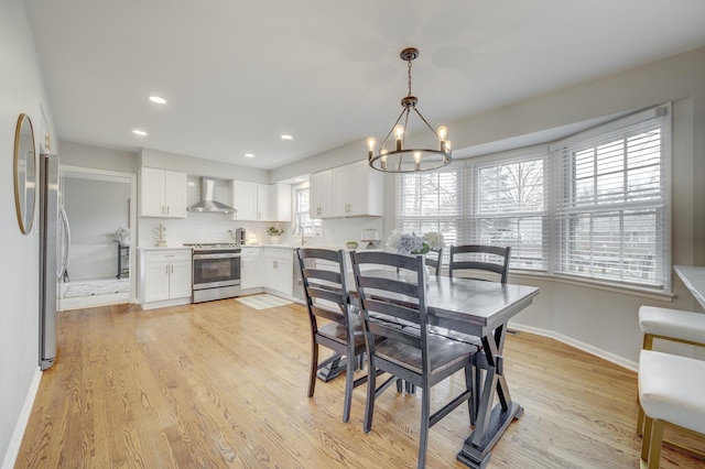 dining area with recessed lighting, light wood-style floors, baseboards, and an inviting chandelier