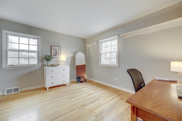 office space with baseboards, wood finished floors, and visible vents