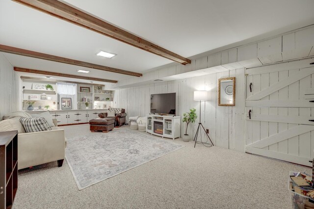 living room with wood walls, beamed ceiling, and carpet