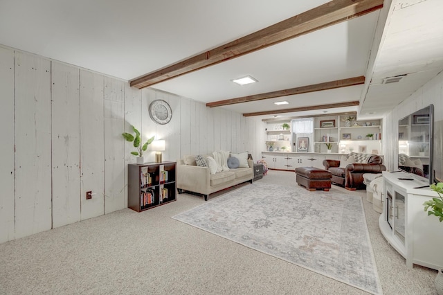 carpeted living area with wooden walls, visible vents, and beam ceiling