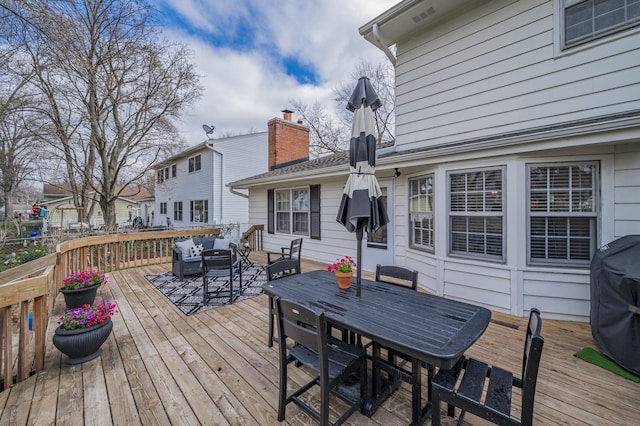 wooden deck with grilling area, an outdoor hangout area, and outdoor dining space