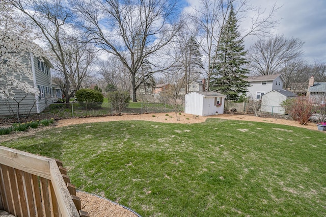 view of yard featuring a fenced backyard, an outbuilding, a residential view, and a storage unit